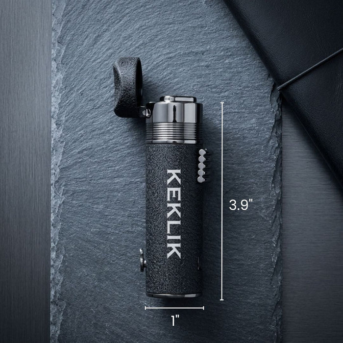 Black textured cigar lighter with "KEKLIK" engraved vertically, chrome dual-flame head, leather carrying loop, and measurement indicators showing 3.9 inches tall and 1 inch wide.