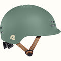 Green toddler bike helmet with a brown strap on a white background.