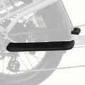 A close-up of a black textured bicycle passenger foot board mounted on a bicycle frame, with the rear wheel and chain visible in the background.