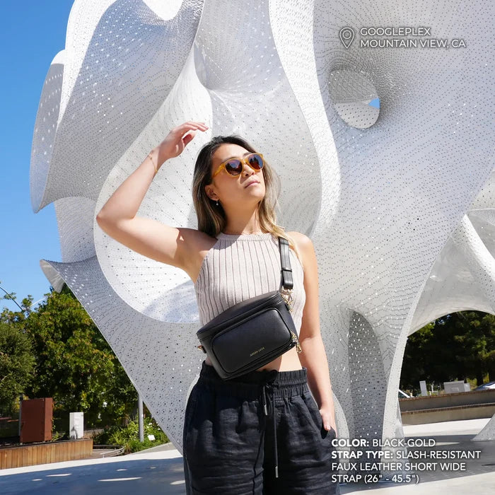 Anti-theft water-resistant Bum Bag Crossbody in black with gold hardware and slash-resistant short wide faux leather strap on model