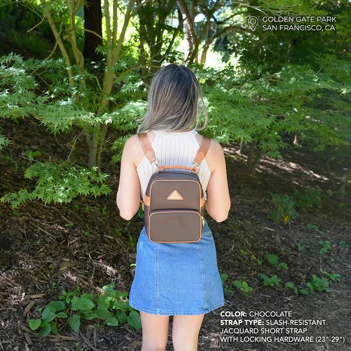 Model wearing anti-theft water-resistant Carmel convertible backpack in brown/gold with slash-resistant jacquard straps