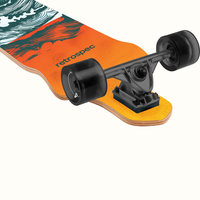 A close-up of a retro-style Tidal Drop Down Longboard skateboard featuring a vibrant orange and teal design, showcasing its truck and black wheels.