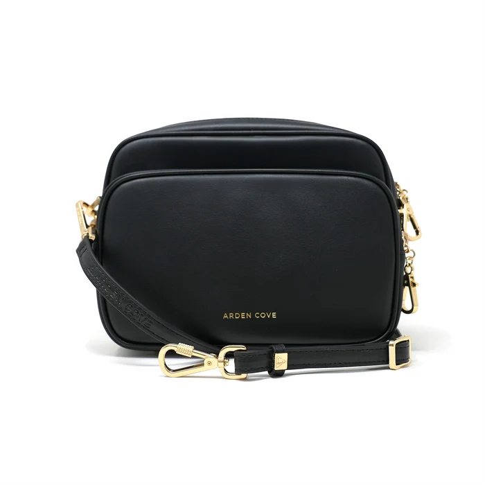 Verona Crossbody with slash resistant faux leather strap. Black faux leather handbag with gold accents front view